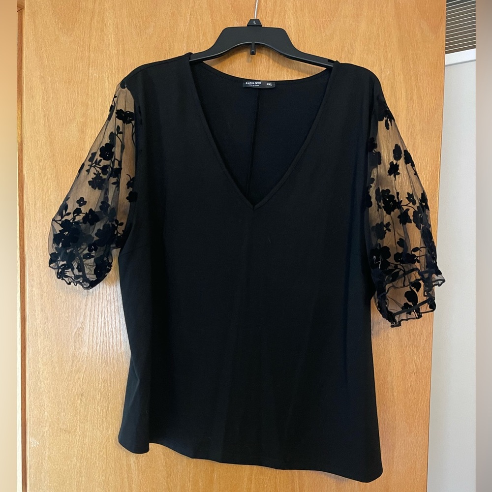 Black top with floral lace sleeves.